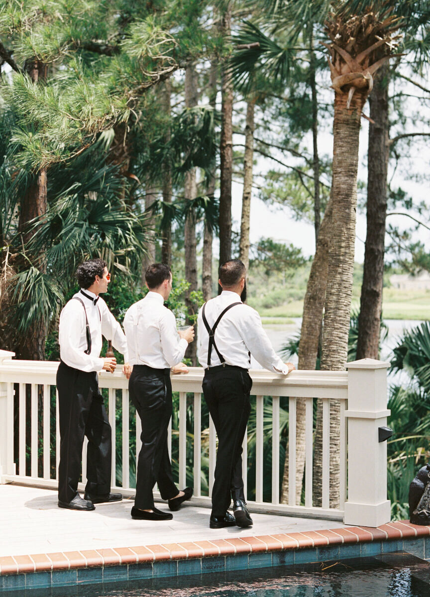 Groomsmen look out at the South Carolina setting where their friend's elegant spring wedding took place.