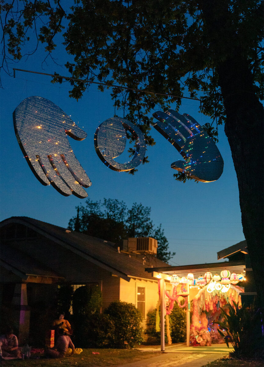 The yard was all aglow, with a dimensional art installation hanging from a tree, at this vibrant, outdoor wedding.